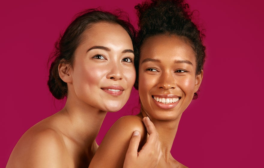 Duas modelos de etnias diferentes abraçadas e sorrindo